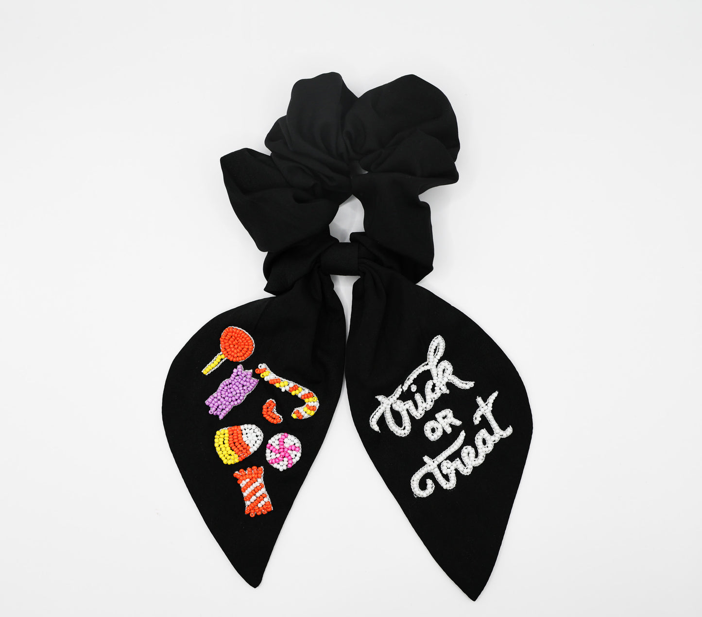 Black hair scrunchie with 'Treat or Treat' text and Halloween-themed designs on a white background