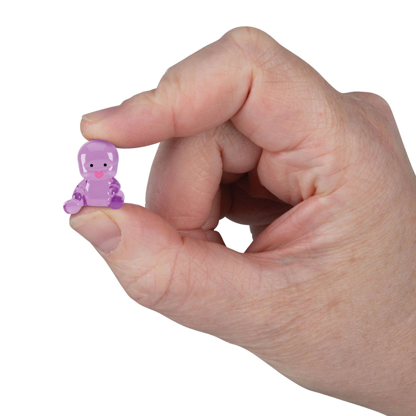 Hand holding a small purple figurine against a white background