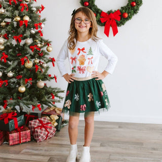 Girl wearing green sequin gingerbread Christmas tutu skirt with white holiday top