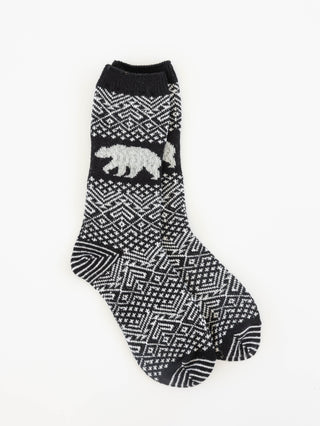 A single black and white patterned crew sock with a white polar bear motif on the side, displayed against a plain white background.