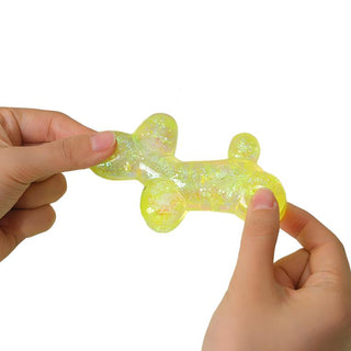 Yellow glitter gel squish balloon dog toy being squeezed by two hands