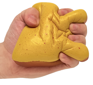Hand squishing yellow speckled cheese toast squishy toy with brown base