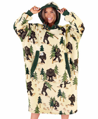 Woman wearing LazyOne Bigfoot Blanket Hoodie with cream background and Sasquatch forest pattern