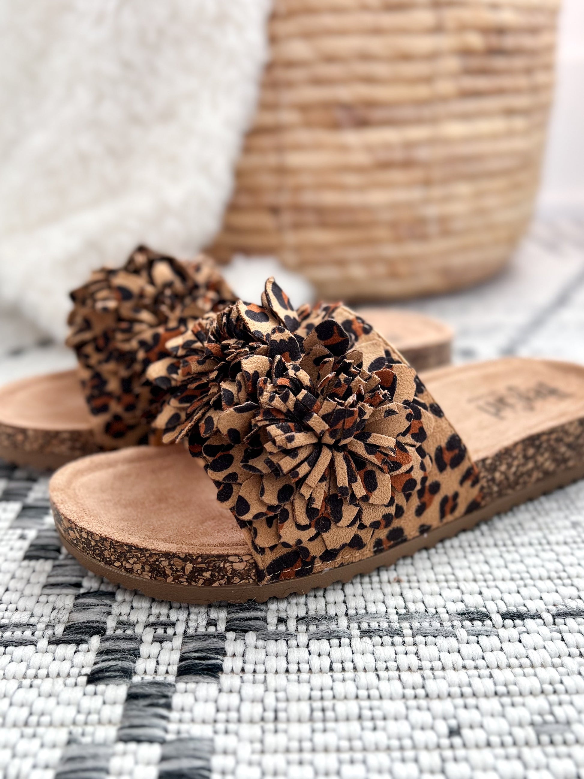 Corkys Wild Child leopard print slide sandals with pom-pom detail on woven rug