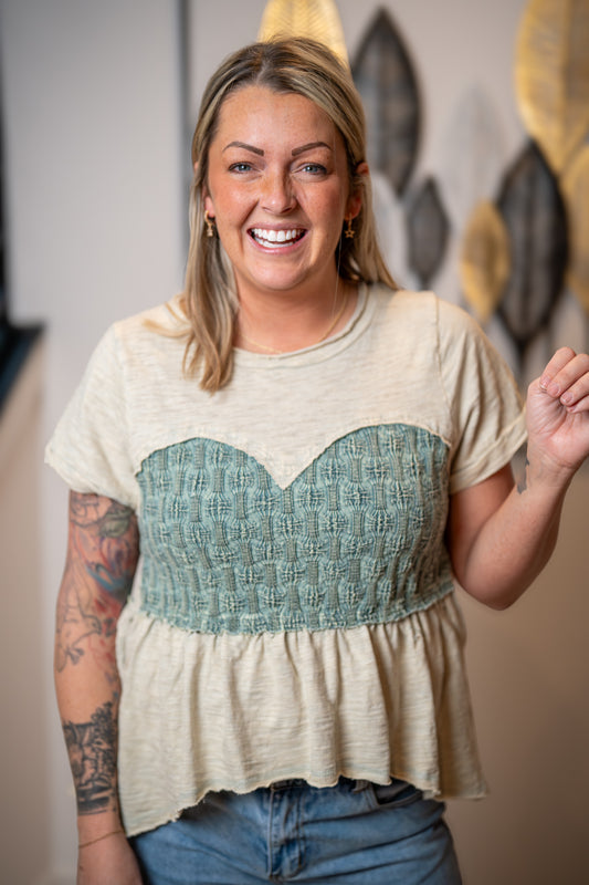 Close up of Oli and Hali sage smocked top with textured bodice, soft fabric and peplum hem