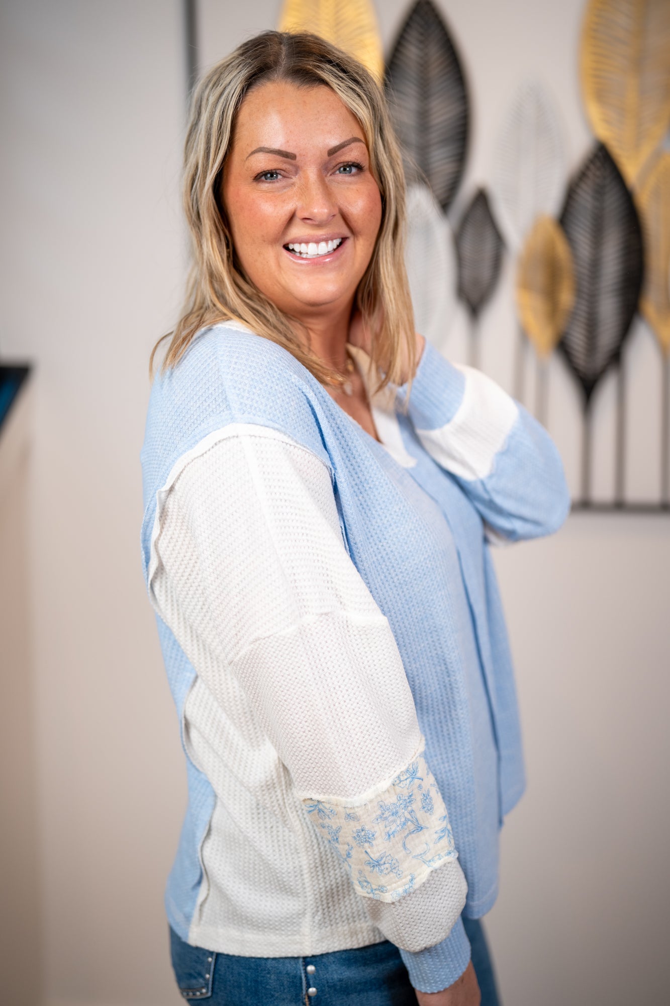 side view Patchwork waffle knit top with mixed floral print sleeves and oversized relaxed silhouette.