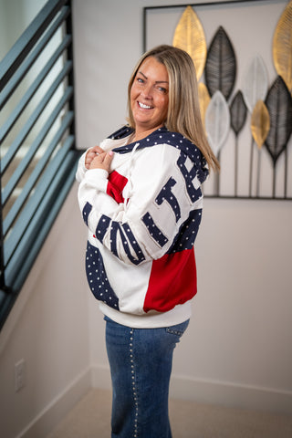 Woman wearing a colorful sweatshirt with a abstract leaf painting in the background