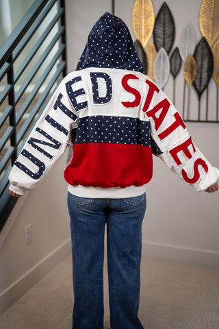 Person wearing a hoodie with 'United States' text in red, white, and blue.