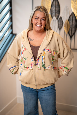Tan zip-up hoodie with colorful patchwork PEACE letter appliqués and floral details
