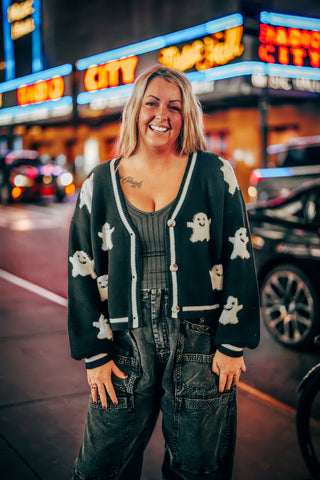 Black knit cardigan with white ghost pattern and button front closure