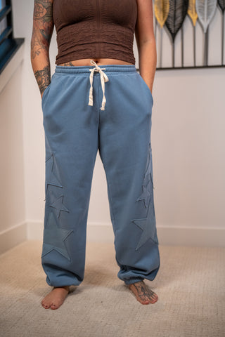 Blue star patch jogger sweatpants with white drawstring and cuffed ankles