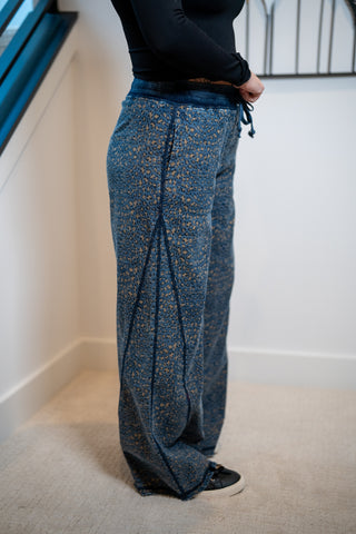 Person wearing blue patterned pants in a minimal indoor setting