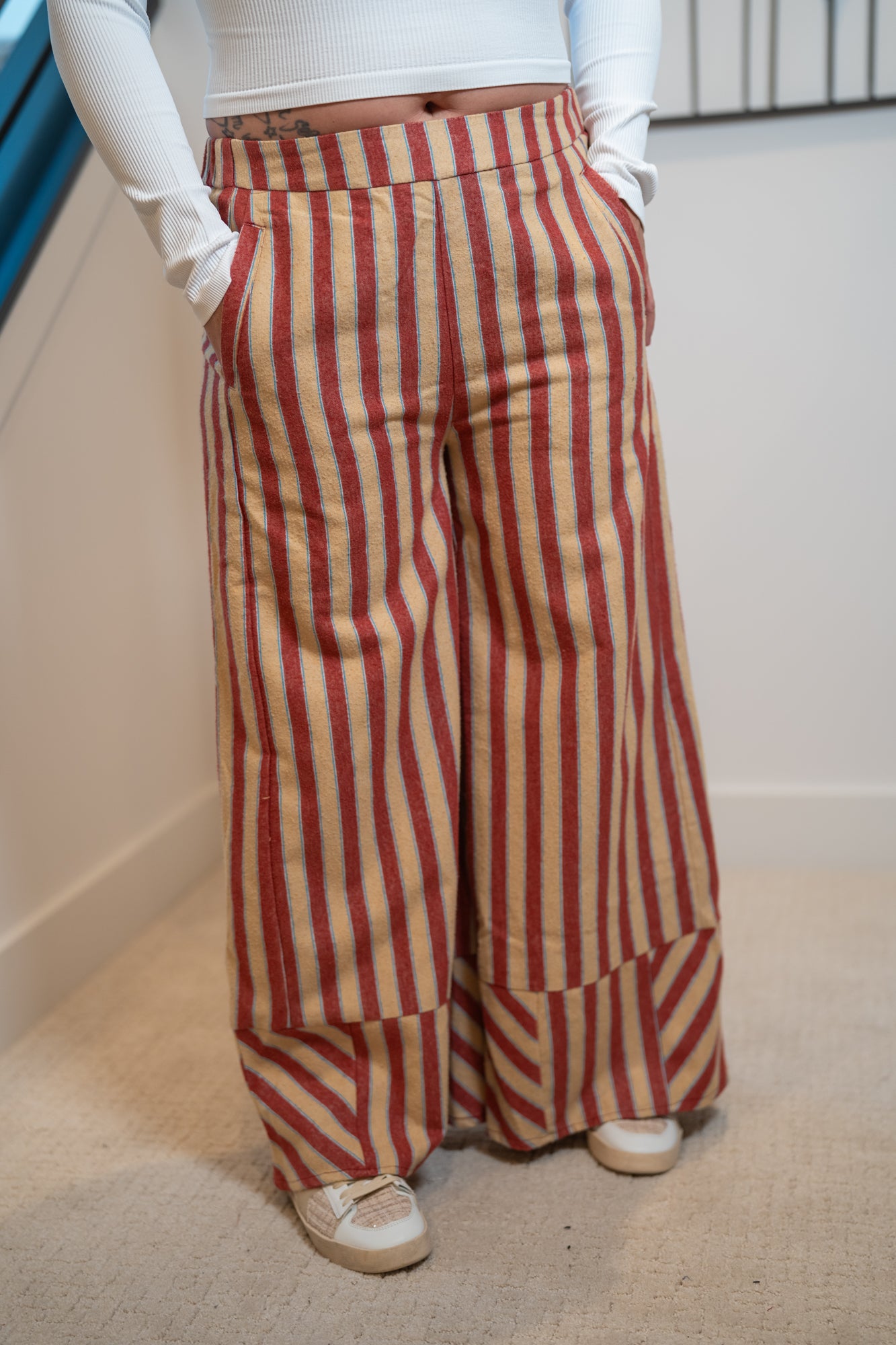 Person wearing Striped Wide Leg Easel Palazzo pants with hands in the pockets. 