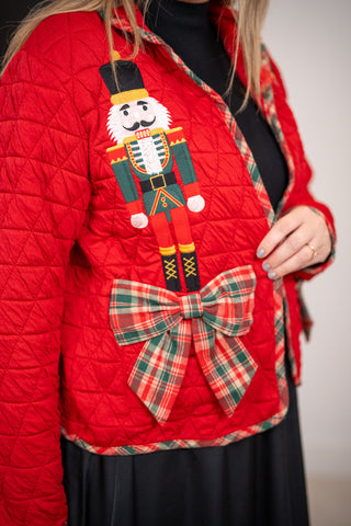 Red quilted jacket with nutcracker embroidery and plaid bow accent