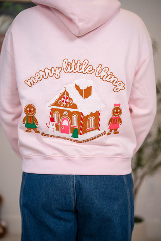 Pink hoodie back with gingerbread house, figures, and merry little thing embroidery