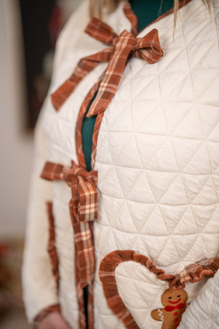 Cream quilted jacket with plaid bows, ruffled heart pocket, and gingerbread man appliqué