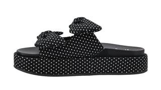 Side view of Corkys Lil Bit Knotty black polka dot platform sandals with double bow straps