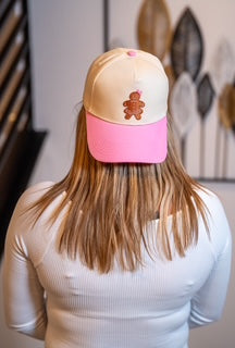 Woman smiling wearing the Pink Sugar Gingerbread Girl Cap backward, cream and pink hat.