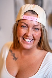 Back view showing the embroidered gingerbread girl and pink snapback strap.