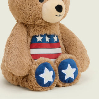 Brown plush teddy bear with American flag belly and blue star-print foot pads