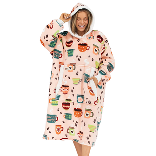 Woman wearing LazyOne Coffee Club Blanket Hoodie with colorful coffee mug print on pink background