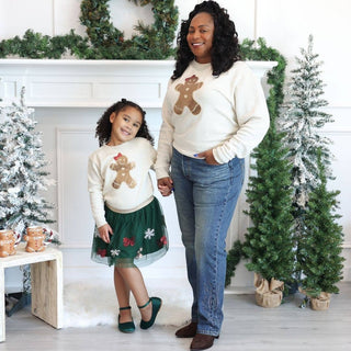 Girl wearing cream gingerbread sequin patch sweatshirt with green tulle skirt
