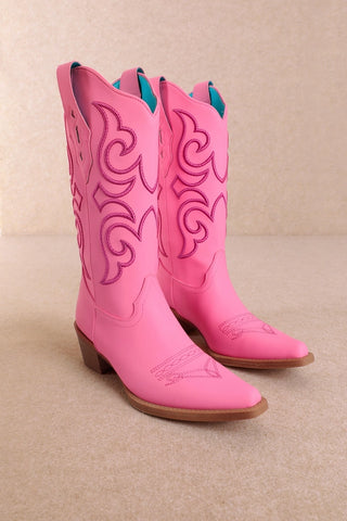 Hot pink cowboy boots with darker pink embroidered scroll designs and stacked heel
