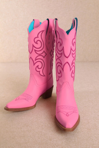 Pink cowboy boots with embroidered western stitching detail and teal interior lining