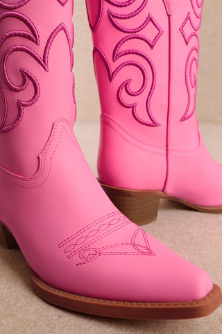 Pink cowboy boots with hot pink embroidered scroll details and stacked heel