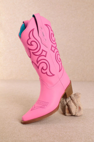 Hot pink cowboy boots with darker pink embroidery stitching and stacked heel